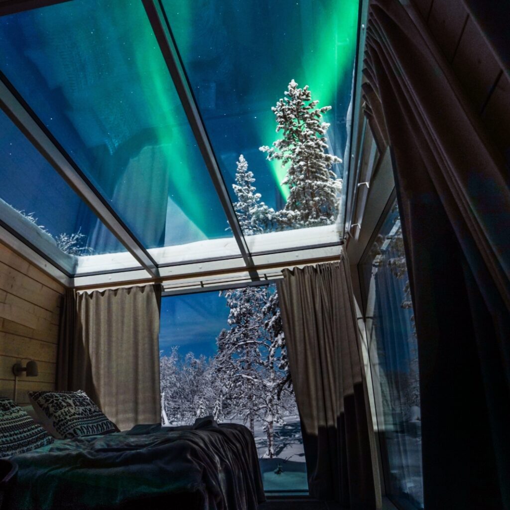 Kirkkaat revotulet Sky View Cabin -iglumökin lasikaton yläpuolella.